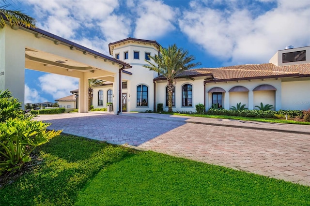 mediterranean / spanish-style house featuring a front yard