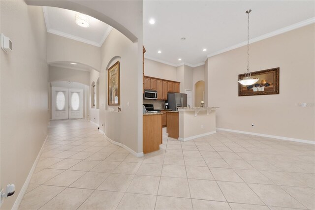 kitchen featuring a breakfast bar area, pendant lighting, light tile patterned floors, appliances with stainless steel finishes, and ornamental molding