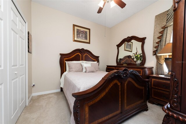 bedroom featuring a closet, ceiling fan, and light carpet