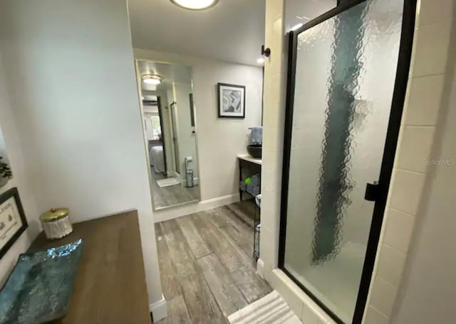 bathroom featuring wood-type flooring and an enclosed shower