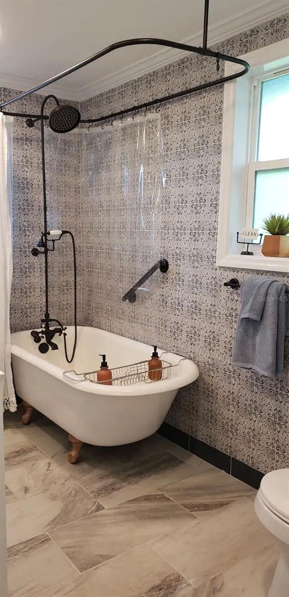 bathroom with separate shower and tub, ornamental molding, and toilet