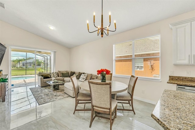 dining space with lofted ceiling and a notable chandelier