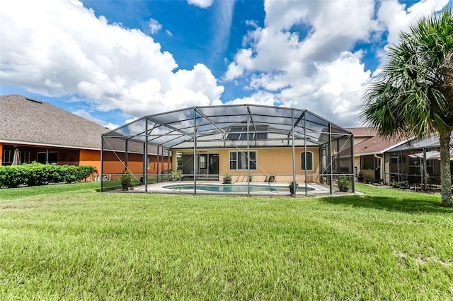 back of house with glass enclosure and a yard