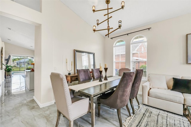 dining space with high vaulted ceiling, an inviting chandelier, and plenty of natural light