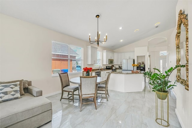 dining area featuring an inviting chandelier and lofted ceiling