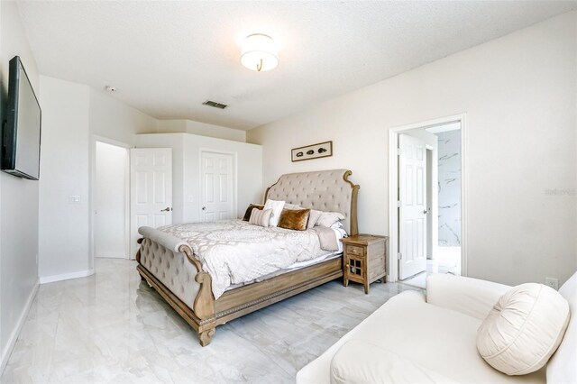 bedroom featuring connected bathroom and a textured ceiling