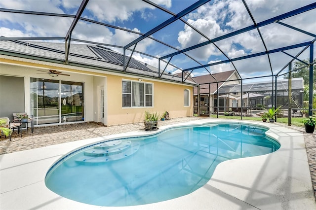 view of swimming pool with a lanai, ceiling fan, and a patio area