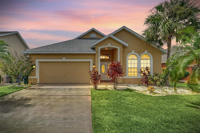 view of front of house with a yard and a garage