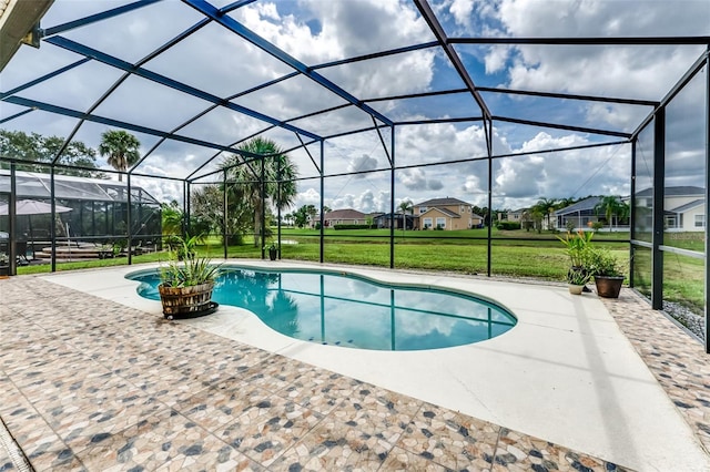 view of swimming pool with a lawn, a patio area, and a lanai