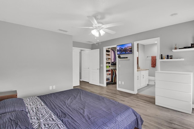 bedroom featuring a closet, light wood-type flooring, ceiling fan, and ensuite bathroom