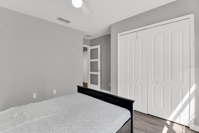 bedroom with wood-type flooring, ceiling fan, and a closet