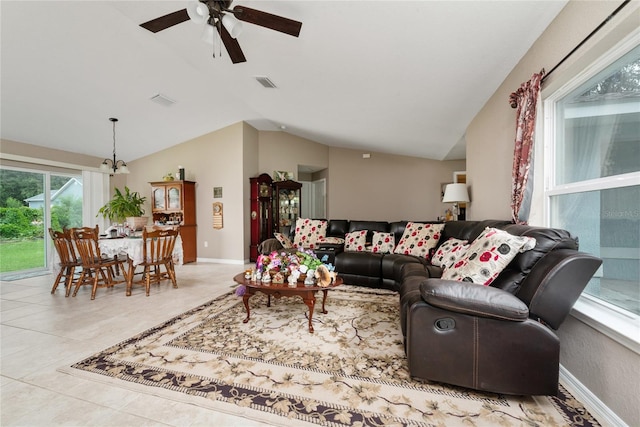 living room featuring lofted ceiling, ceiling fan, and light tile patterned flooring