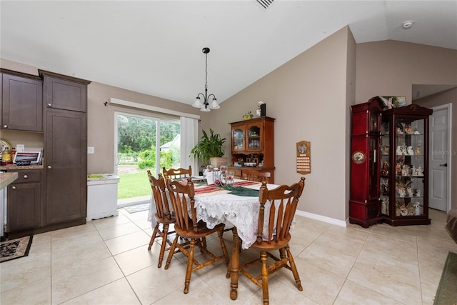 tiled dining room with vaulted ceiling and an inviting chandelier