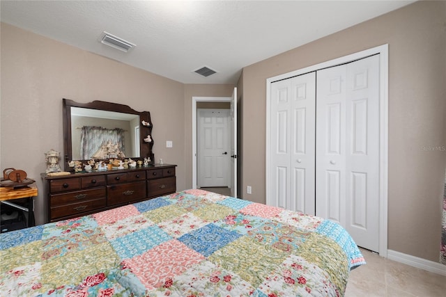 tiled bedroom with a closet and a textured ceiling