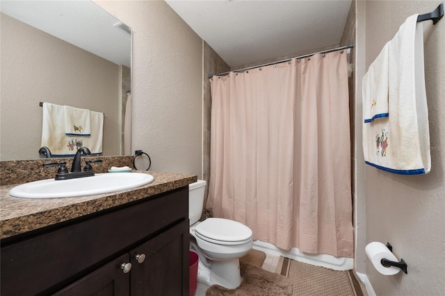 bathroom with tile patterned flooring, vanity, toilet, and walk in shower