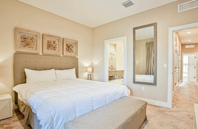 bedroom featuring connected bathroom and light carpet