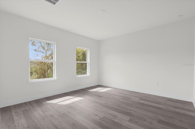 spare room featuring baseboards and wood finished floors