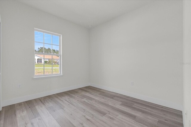 empty room with light wood-type flooring and baseboards