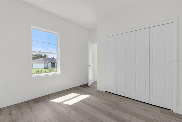 unfurnished bedroom featuring a closet and light hardwood / wood-style floors