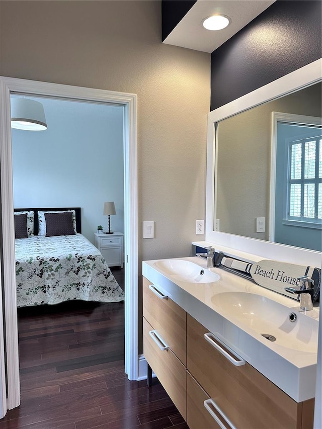 14421 Hatchee Ct, Orlando, FL 32837 - bathroom with double vanity, a sink, ensuite bath, and wood finished floors