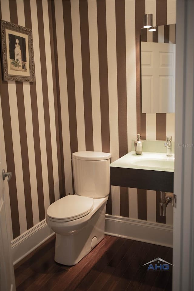 14421 Hatchee Ct, Orlando, FL 32837 - half bath with baseboards, toilet, wallpapered walls, and wood finished floors