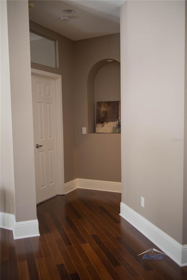 14421 Hatchee Ct, Orlando, FL 32837 - hall with arched walkways, baseboards, and wood finished floors