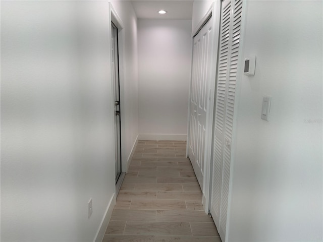corridor featuring recessed lighting, baseboards, and wood finish floors