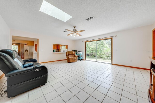 living room with a textured ceiling, a healthy amount of sunlight, and a skylight