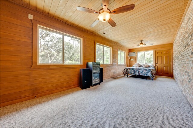 unfurnished bedroom with wooden ceiling, brick wall, carpet, and ceiling fan