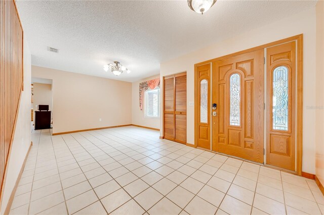 entrance foyer with a textured ceiling and light tile patterned floors