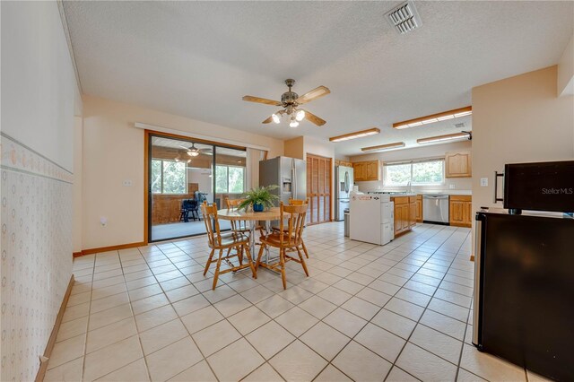 tiled dining space with ceiling fan and a textured ceiling