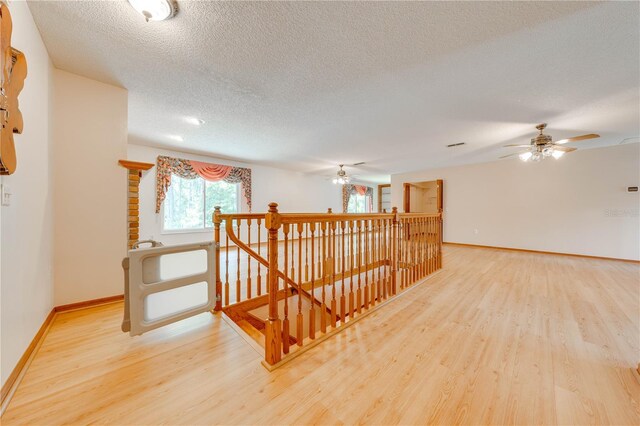 hall with a textured ceiling and hardwood / wood-style floors