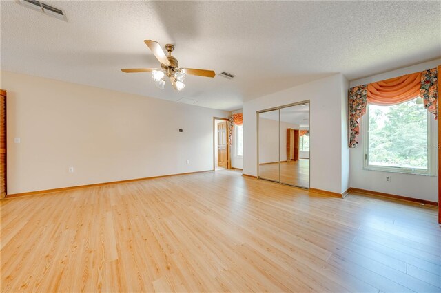 spare room with a textured ceiling, hardwood / wood-style flooring, and ceiling fan