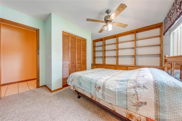 bedroom with a closet, ceiling fan, light carpet, and a textured ceiling