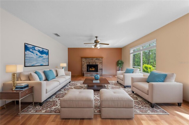 1775 Sundance Dr, Saint Cloud, FL 34771 - living area with wood finished floors, ceiling fan, and a brick fireplace