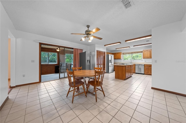 1775 Sundance Dr, Saint Cloud, FL 34771 - dining space with ceiling fan, baseboards, light tile patterned floors, and a textured ceiling