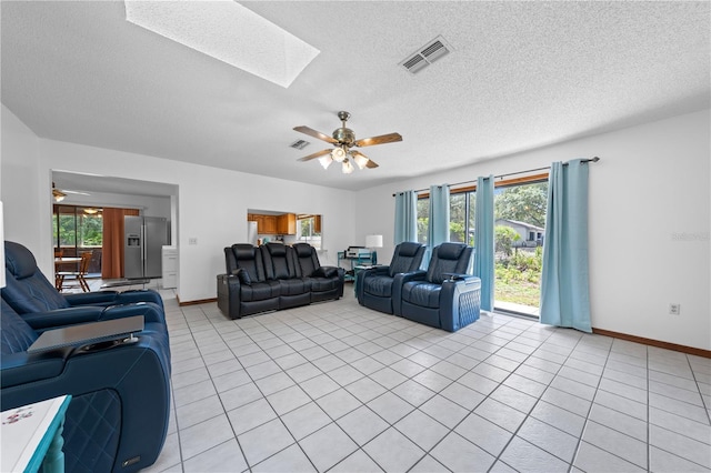 1775 Sundance Dr, Saint Cloud, FL 34771 - living area featuring a ceiling fan, a skylight, light tile patterned flooring, plenty of natural light, and a textured ceiling