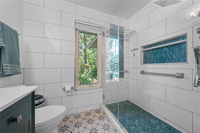 1775 Sundance Dr, Saint Cloud, FL 34771 - bathroom featuring a stall shower, toilet, tile walls, tile patterned floors, and vanity