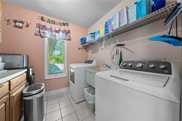 1775 Sundance Dr, Saint Cloud, FL 34771 - clothes washing area with independent washer and dryer, cabinet space, a textured ceiling, light tile patterned flooring, and baseboards