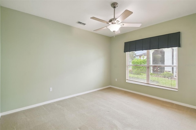 carpeted spare room with ceiling fan