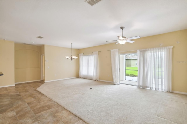 spare room featuring ceiling fan with notable chandelier and light carpet