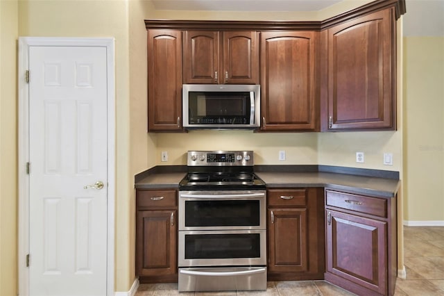 kitchen with light tile patterned flooring and appliances with stainless steel finishes