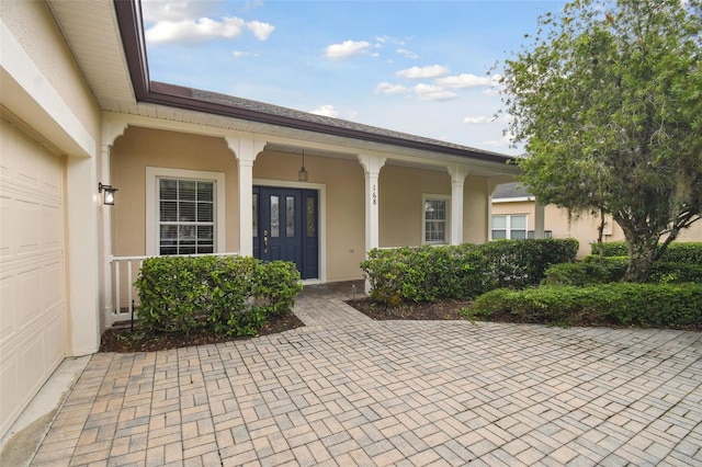 doorway to property featuring a garage and covered porch