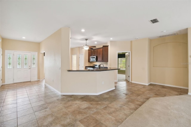 kitchen featuring ceiling fan, light tile patterned floors, sink, kitchen peninsula, and appliances with stainless steel finishes