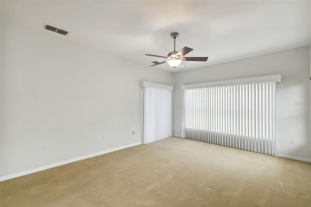 unfurnished room with ceiling fan and light carpet