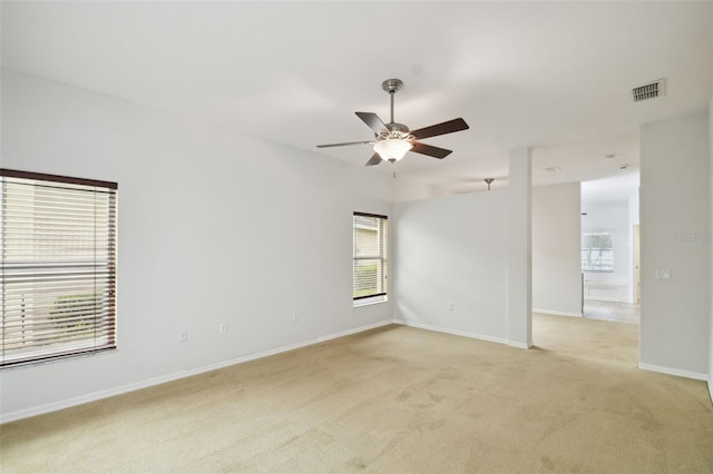 empty room featuring ceiling fan and light carpet