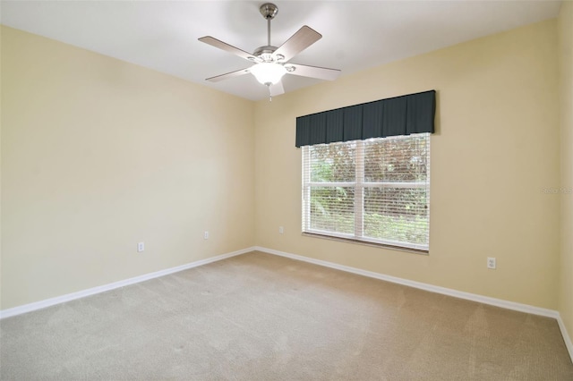 carpeted spare room with ceiling fan