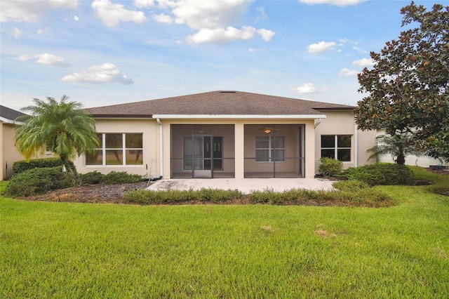 rear view of house with a yard and a sunroom