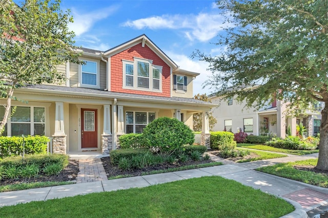 craftsman inspired home featuring a porch and a front yard