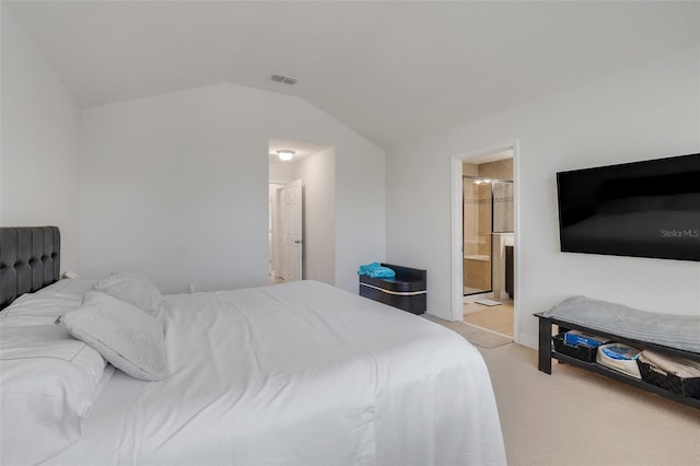 carpeted bedroom with vaulted ceiling and ensuite bathroom